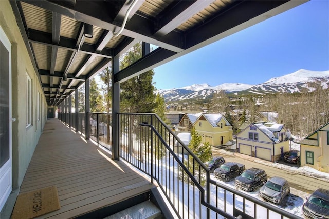 snow covered back of property featuring a mountain view