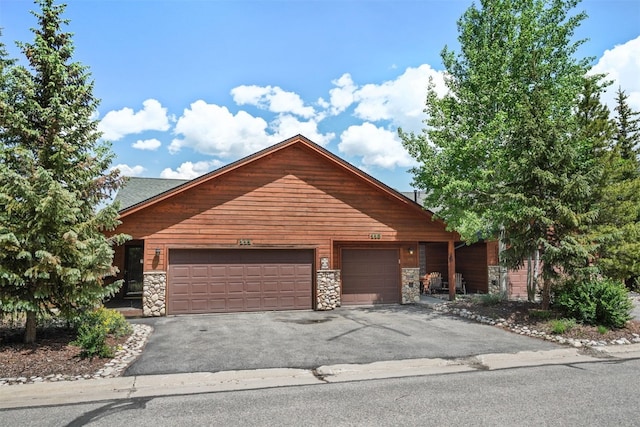 113 Lookout Ridge Dr, Dillon, CO 80435 - rustic home featuring stone siding, driveway, and an attached garage