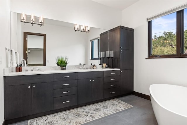 2355 Poma Ln Unit 2355, Steamboat Springs, CO 80487 - full bath featuring a chandelier, double vanity, a freestanding tub, tile patterned flooring, and baseboards