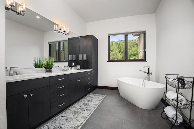 2355 Poma Ln Unit 2355, Steamboat Springs, CO 80487 - bathroom with double vanity, a soaking tub, baseboards, a chandelier, and tile patterned flooring