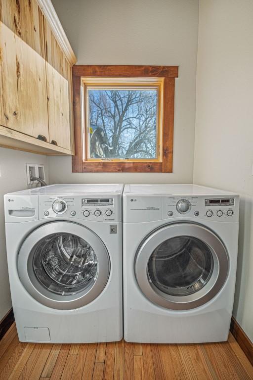 527 E Lincoln Ave, Hayden, CO 81639 - laundry room with separate washer and dryer, cabinet space, wood finished floors, and baseboards