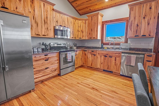 527 E Lincoln Ave, Hayden, CO 81639 - kitchen featuring stainless steel appliances, a sink, lofted ceiling, light wood-style floors, and dark stone countertops
