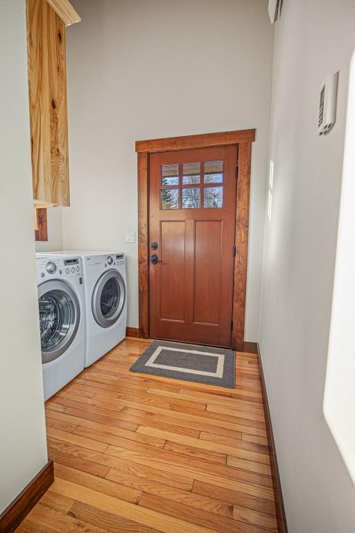 527 E Lincoln Ave, Hayden, CO 81639 - laundry room featuring washer and dryer, light wood-style floors, and baseboards