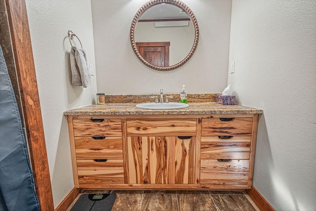 527 E Lincoln Ave, Hayden, CO 81639 - bathroom featuring vanity, baseboards, a textured wall, and wood finished floors