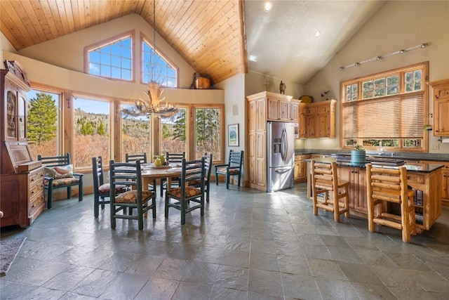 105 Windflower Ln, Frisco, CO 80443 - dining area featuring stone tile flooring, a chandelier, and high vaulted ceiling