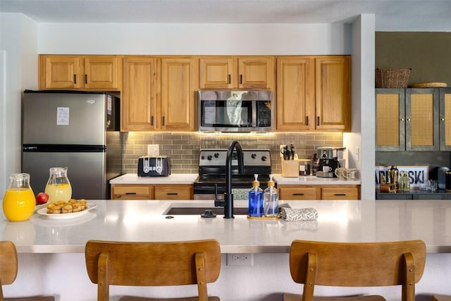 2700 Village Dr Unit D203, Steamboat Springs, CO 80487 - kitchen with appliances with stainless steel finishes, light countertops, decorative backsplash, and a breakfast bar