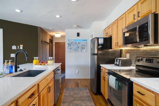 2700 Village Dr Unit D203, Steamboat Springs, CO 80487 - kitchen featuring stainless steel appliances, a sink, dark wood-style flooring, light countertops, and decorative backsplash