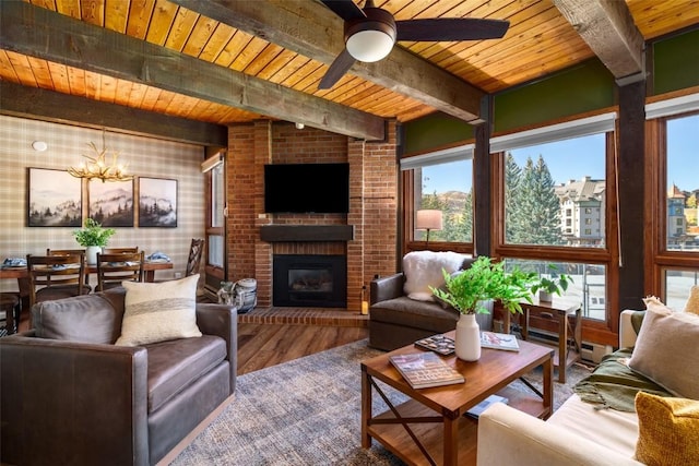 2700 Village Dr Unit D203, Steamboat Springs, CO 80487 - living room with wooden ceiling, beamed ceiling, wood finished floors, a brick fireplace, and a ceiling fan