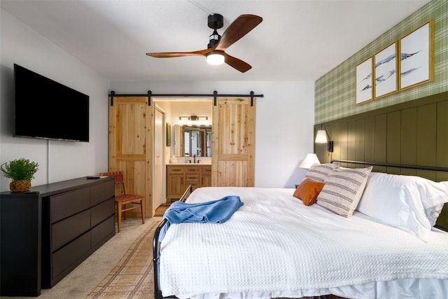 2700 Village Dr Unit D203, Steamboat Springs, CO 80487 - bedroom featuring a barn door, light carpet, ensuite bath, and ceiling fan