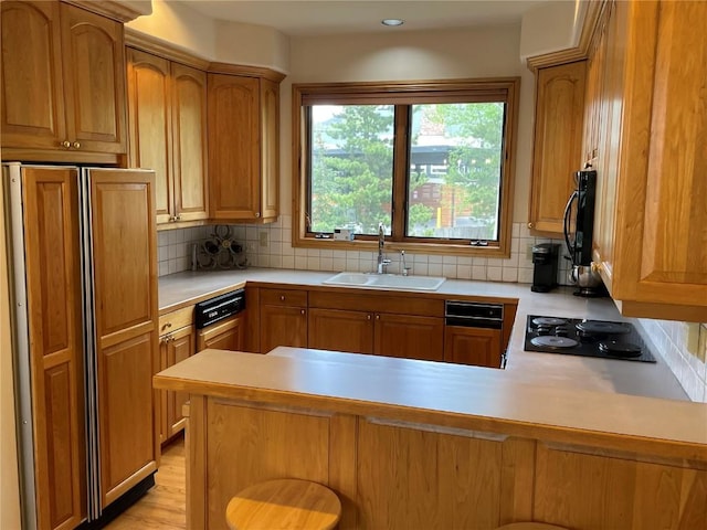 2300 Apres Ski Way Unit 12, Steamboat Springs, CO 80487 - kitchen with paneled built in refrigerator, a sink, a peninsula, black electric stovetop, and light countertops