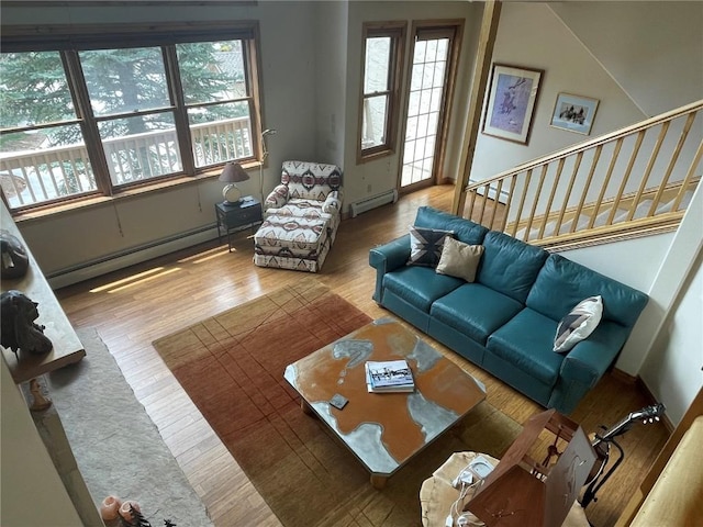 2300 Apres Ski Way Unit 12, Steamboat Springs, CO 80487 - living room with baseboard heating, wood finished floors, stairs, vaulted ceiling, and baseboards