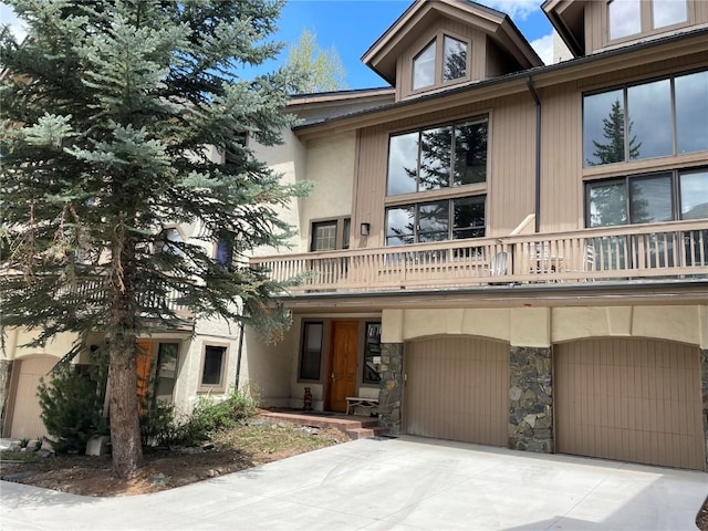 2300 Apres Ski Way Unit 12, Steamboat Springs, CO 80487 - view of front of house featuring a balcony, a garage, driveway, and stone siding