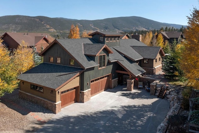 27 Habitat Ct, Dillon, CO 80435 - view of front of property with board and batten siding, stone siding, roof with shingles, driveway, and a mountain view