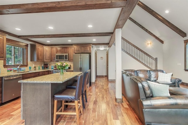 554 Lakeview Dr, Breckenridge, CO 80424 - kitchen with appliances with stainless steel finishes, beam ceiling, tasteful backsplash, a breakfast bar, and light wood finished floors