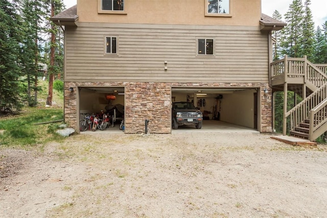 554 Lakeview Dr, Breckenridge, CO 80424 - view of side of home featuring an attached garage, stairs, stone siding, and dirt driveway