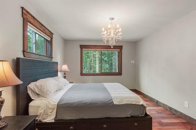 554 Lakeview Dr, Breckenridge, CO 80424 - bedroom with multiple windows, a chandelier, wood finished floors, and baseboards