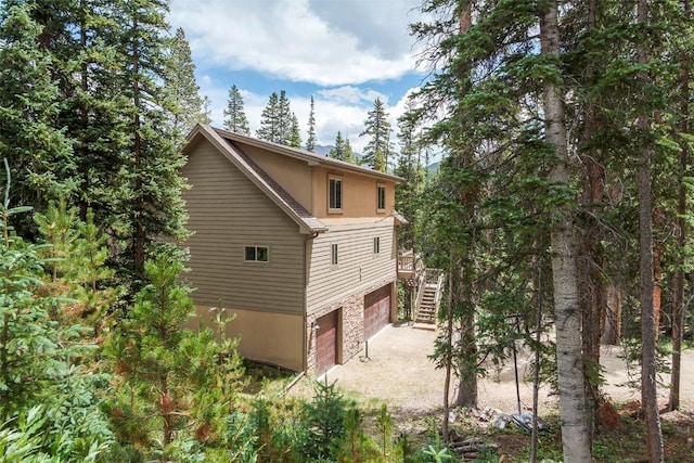 554 Lakeview Dr, Breckenridge, CO 80424 - view of property exterior with stairs, an attached garage, driveway, and stone siding