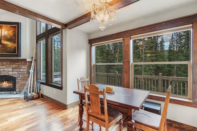 554 Lakeview Dr, Breckenridge, CO 80424 - dining area with a chandelier, light wood finished floors, a fireplace, baseboards, and beam ceiling