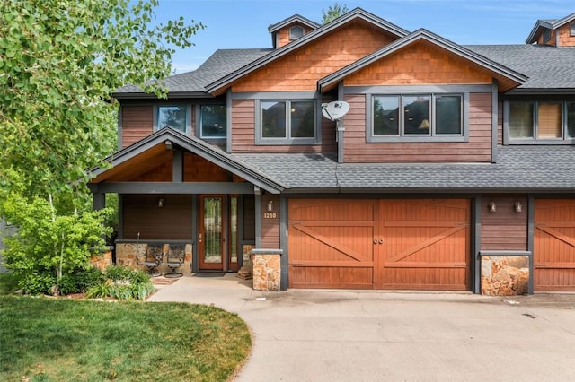1250 Harwig Cir, Steamboat Springs, CO 80487 - view of front facade with a shingled roof, driveway, stone siding, and a garage