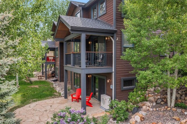 1250 Harwig Cir, Steamboat Springs, CO 80487 - back of property with a patio area, a balcony, ac unit, and a shingled roof