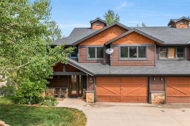 1250 Harwig Cir, Steamboat Springs, CO 80487 - rustic home with roof with shingles, an attached garage, concrete driveway, and stone siding