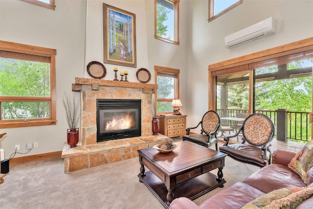 1250 Harwig Cir, Steamboat Springs, CO 80487 - living room featuring a towering ceiling, an AC wall unit, a stone fireplace, carpet flooring, and baseboards