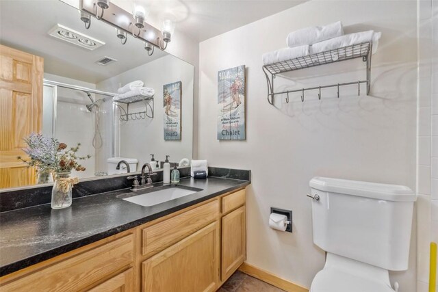 full bathroom with toilet, a shower stall, vanity, and baseboards