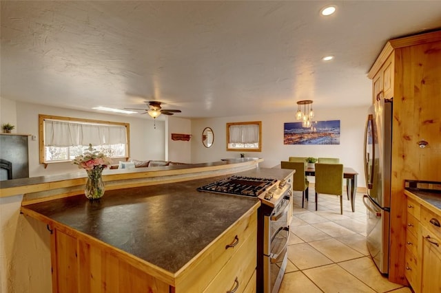 kitchen with dark countertops, recessed lighting, a chandelier, appliances with stainless steel finishes, and light tile patterned floors