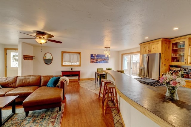 living area featuring recessed lighting, baseboards, and ceiling fan with notable chandelier