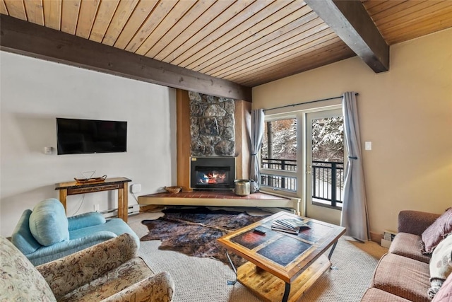 living area with a baseboard heating unit, wood ceiling, beamed ceiling, a fireplace, and baseboards