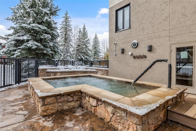 view of pool featuring an in ground hot tub and fence