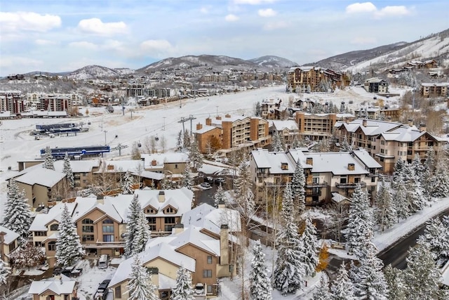 snowy aerial view with a residential view and a mountain view