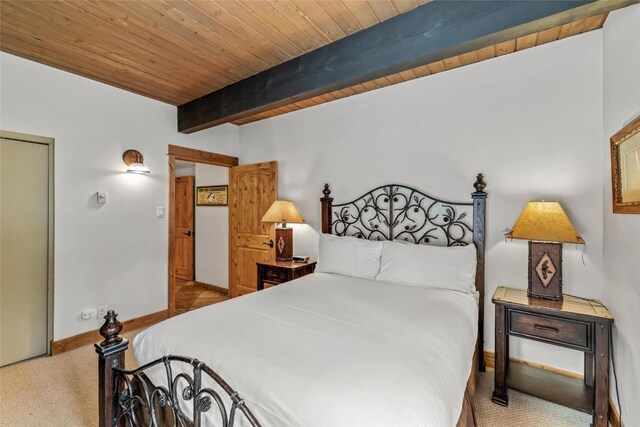 carpeted bedroom featuring beamed ceiling, baseboards, and wood ceiling