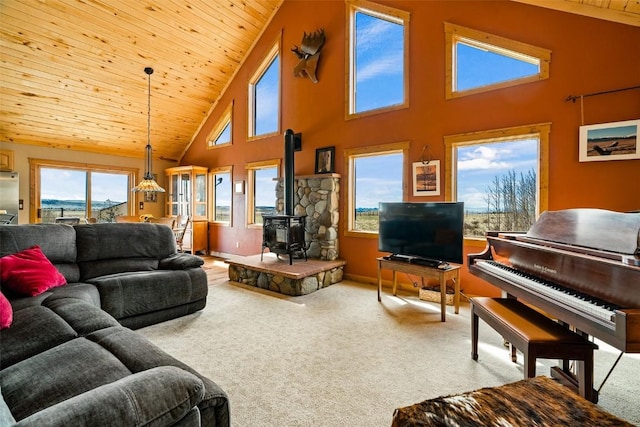 188 June Grass Ct, Fairplay, CO 80440 - carpeted living area featuring a wood stove, high vaulted ceiling, wood ceiling, and healthy amount of natural light