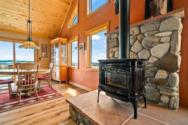 188 June Grass Ct, Fairplay, CO 80440 - dining area featuring a wood stove, plenty of natural light, wood finished floors, wood ceiling, and high vaulted ceiling