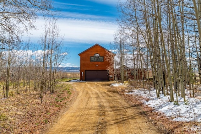 188 June Grass Ct, Fairplay, CO 80440 - snow covered property with driveway, an outbuilding, an attached garage, and a barn