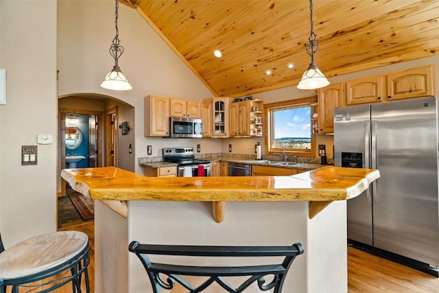 188 June Grass Ct, Fairplay, CO 80440 - kitchen with stainless steel appliances, light wood-style flooring, wood ceiling, a kitchen breakfast bar, and glass insert cabinets