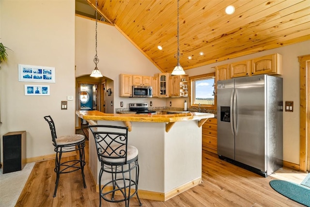 188 June Grass Ct, Fairplay, CO 80440 - kitchen featuring stainless steel appliances, a breakfast bar, glass insert cabinets, a kitchen island, and light wood finished floors