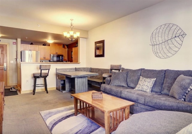 living area featuring light carpet, baseboards, and a chandelier