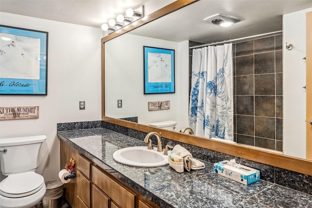 bathroom featuring a shower with curtain, vanity, and toilet