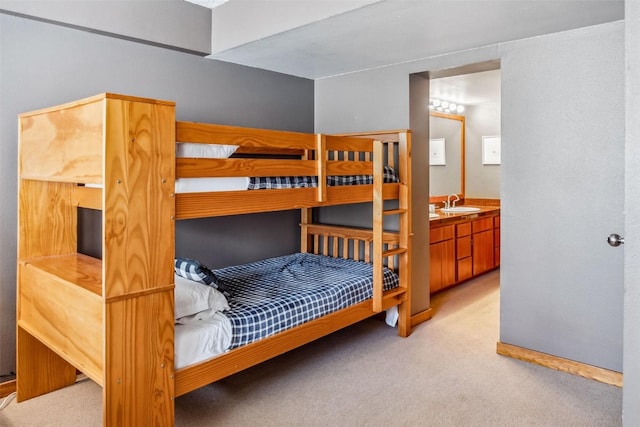 bedroom featuring carpet, baseboards, and a sink