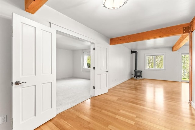31820 Bradley Rnch, Steamboat Springs, CO 80487 - interior space featuring a healthy amount of sunlight, a wood stove, beamed ceiling, and light wood-type flooring