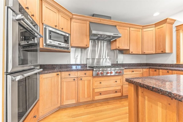 31820 Bradley Rnch, Steamboat Springs, CO 80487 - kitchen featuring wall chimney exhaust hood, dark stone countertops, stainless steel appliances, and light wood-style flooring