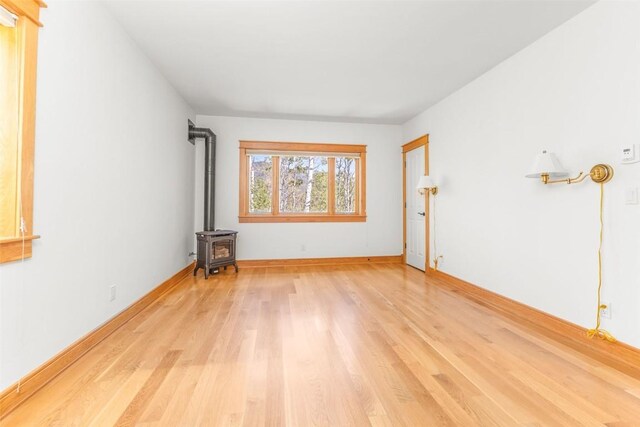 31820 Bradley Rnch, Steamboat Springs, CO 80487 - empty room with light wood-style flooring, a wood stove, and baseboards