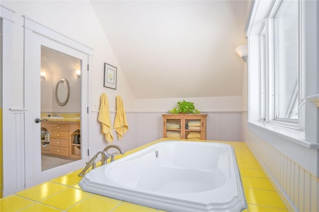 31820 Bradley Rnch, Steamboat Springs, CO 80487 - bathroom featuring a tub to relax in, lofted ceiling, a wainscoted wall, and a sink