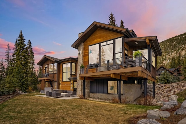 427 Whispering Pines Cir, Blue River, CO 80424 - back of property with a balcony, an outdoor hangout area, a lawn, and a patio area