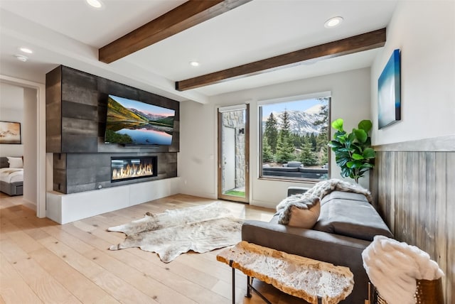 427 Whispering Pines Cir, Blue River, CO 80424 - living area with a large fireplace, recessed lighting, beamed ceiling, and light wood-style floors