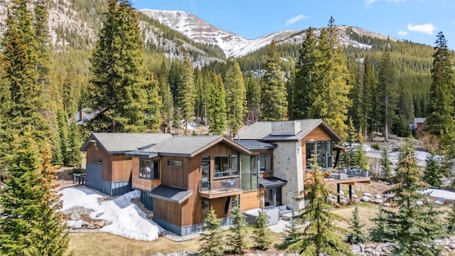 427 Whispering Pines Cir, Blue River, CO 80424 - back of property with a balcony, a forest view, and a mountain view
