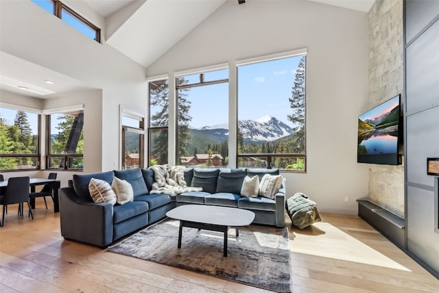 427 Whispering Pines Cir, Blue River, CO 80424 - living area featuring light wood finished floors, healthy amount of natural light, high vaulted ceiling, and a fireplace