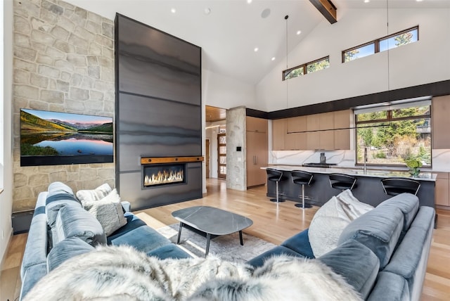 427 Whispering Pines Cir, Blue River, CO 80424 - living room with a glass covered fireplace, light wood-type flooring, beamed ceiling, high vaulted ceiling, and recessed lighting